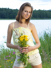 Watch how this stunning brunette teen caresses and later fingers her sweet shaved pussy while being nude on a field.